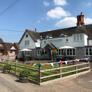 The Falcon at Hatton in the summer with blue skies and bunting along the fence
