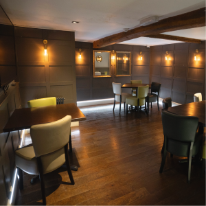 The Nook at The Falcon, a cosy place to dine with green backed chairs and panelled walls
